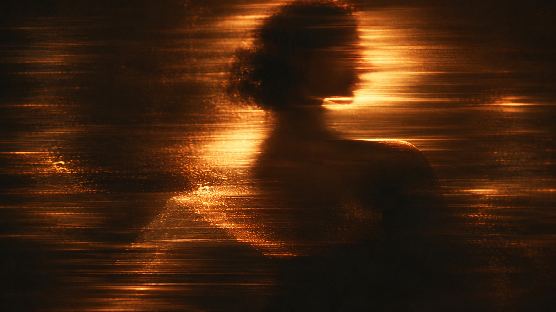 A woman's silhouette dissolving into streaks of golden light